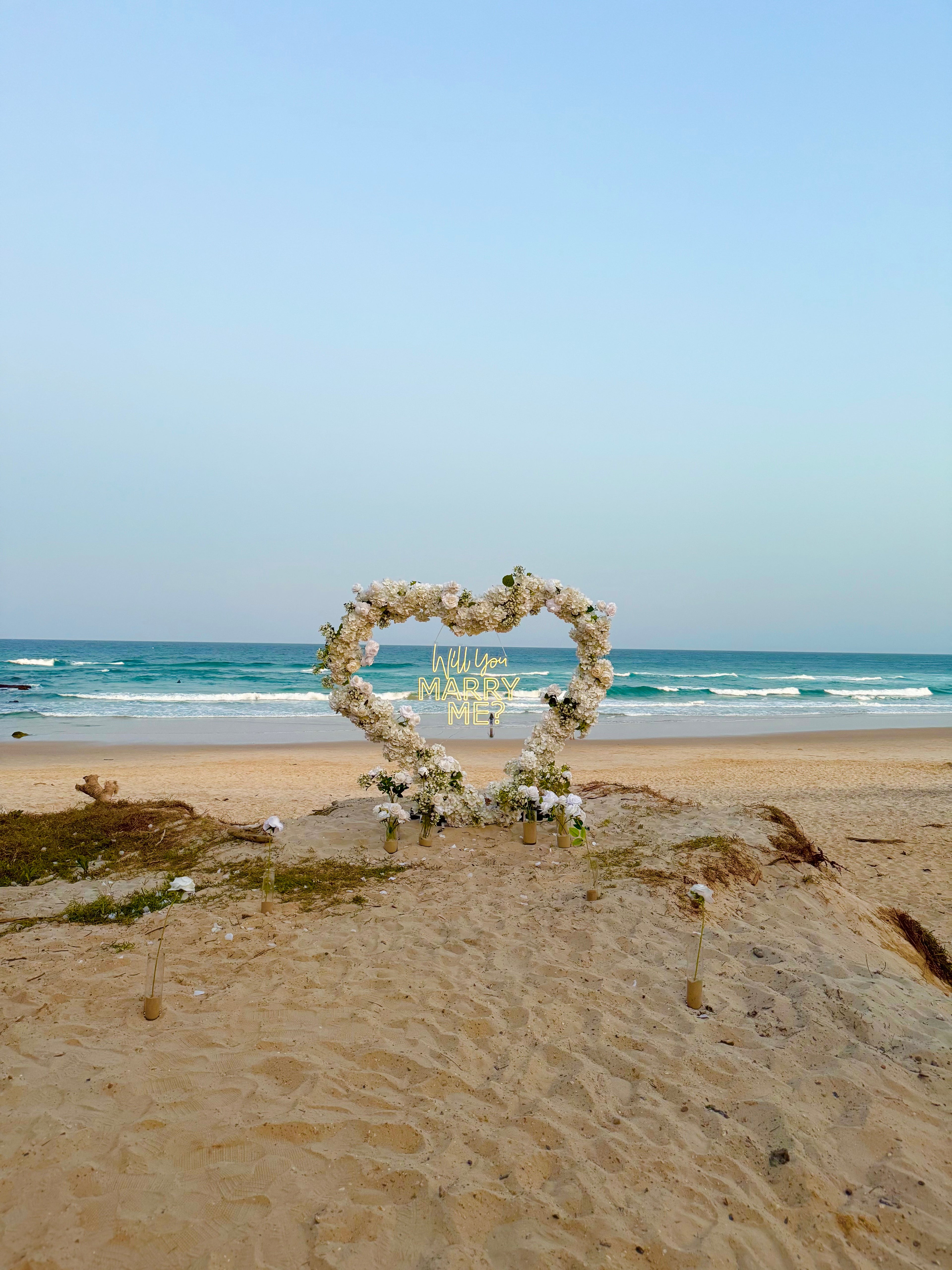 Luxury proposal setup on Gold Coast with floral accents and candles

Romantic Brisbane proposal with personalised signage and flowers

Sunshine Coast intimate proposal with elegant décor and sunset backdrop

Large-scale floral proposal installation for a memorable Gold Coast proposal

Picture-perfect proposal with balloons, florals, and elegant table styling